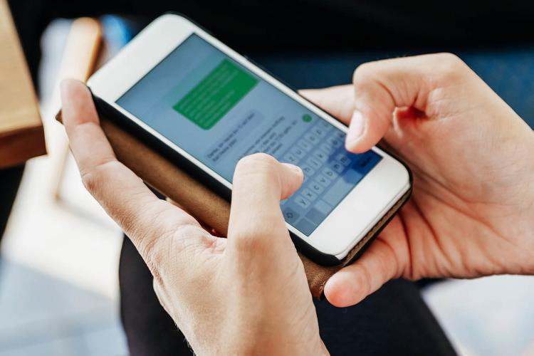 Frau tippt Nachricht auf Smartphone.