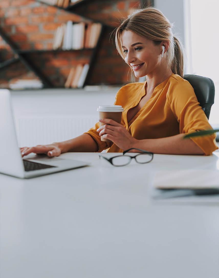 Frau tippt auf ihrem Laptop am Schreibtisch