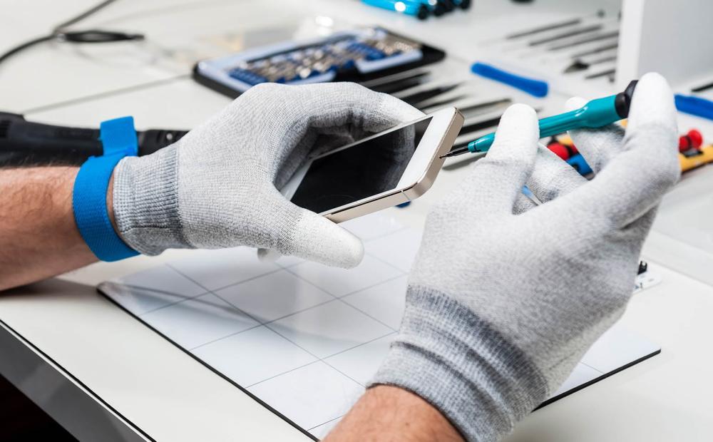 Hände mit Handschuhen öffnen Smartphone-Gehäuse.