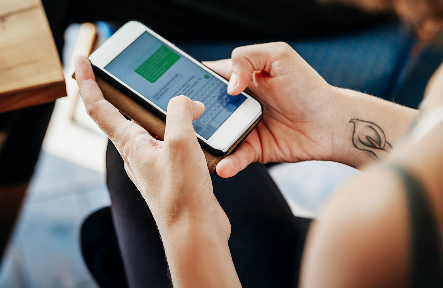 Frau tippt Nachricht auf Smartphone.