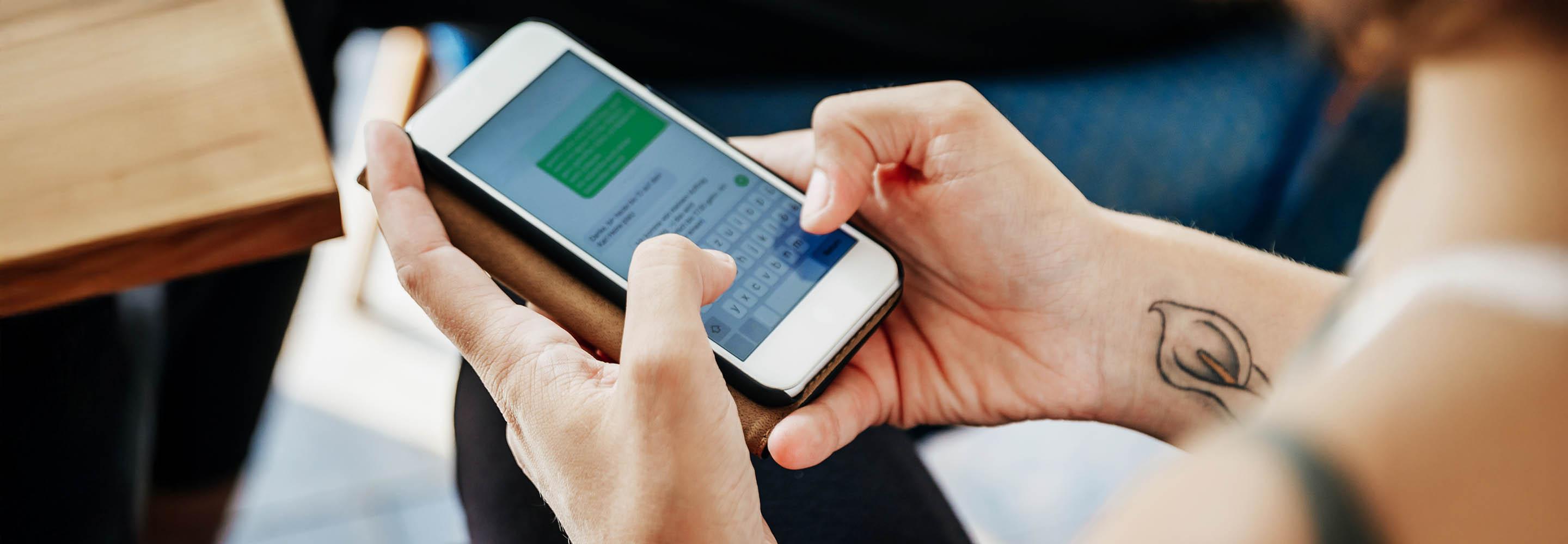 Frau tippt Nachricht auf Smartphone.