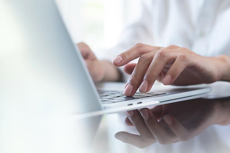 Zwei Hände tippen auf Laptoptastatur