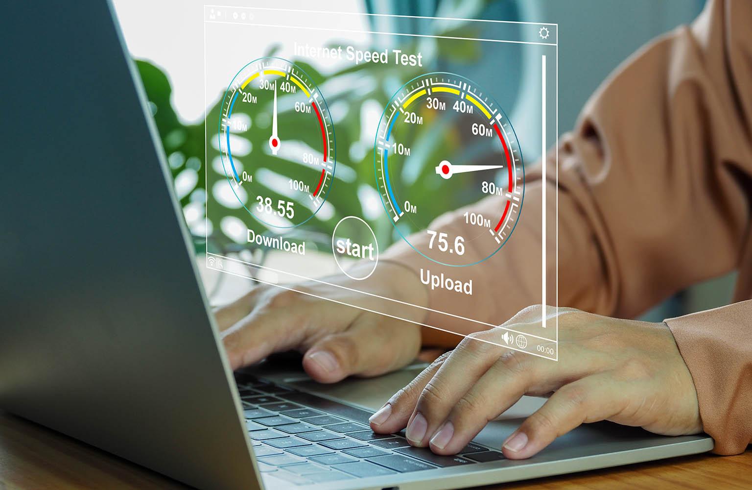 Hände am Laptop mit einer Grafik, die Internetspeeed anzeigt