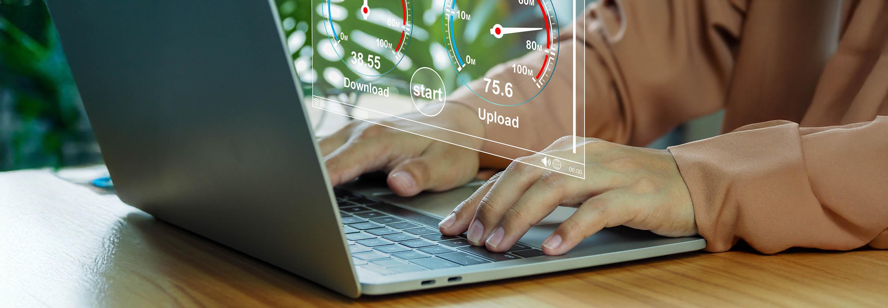 Hände am Laptop mit einer Grafik, die Internetspeeed anzeigt