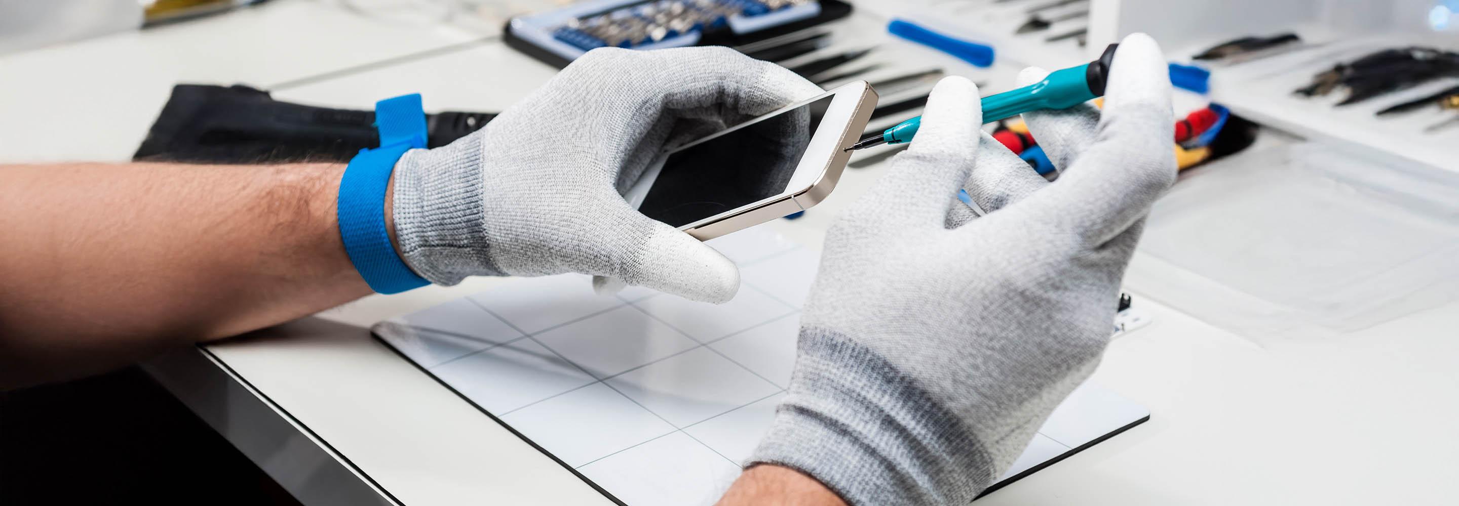 Hände mit Handschuhen öffnen Smartphone-Gehäuse.
