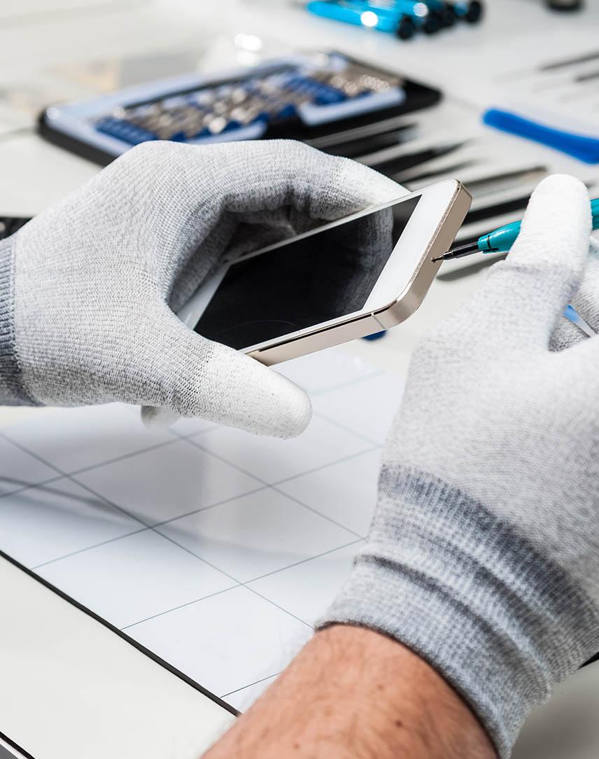 Hände mit Handschuhen öffnen Smartphone-Gehäuse.